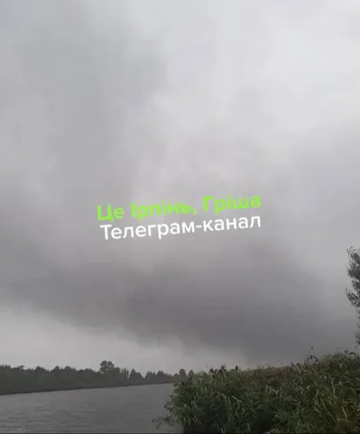 Темне небо над річкою з очеретом під час дощу