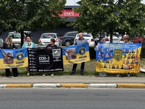 Люди з плакатами та прапорами на вулиці під час акції