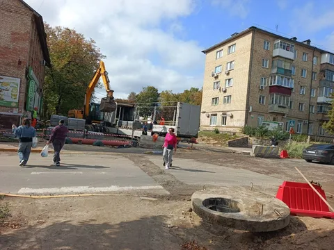 Будівельна техніка та люди на вулиці під час реконструкції