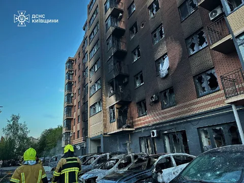 Пошкоджена багатоповерхова будівля з вибитими вікнами та слідами обстрілу