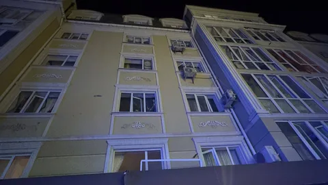Багатоповерхові будинки з пошкодженими вікнами вночі