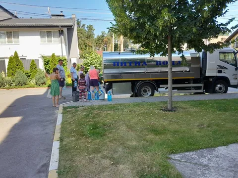 Люди біля вантажівки з питною водою на вулиці