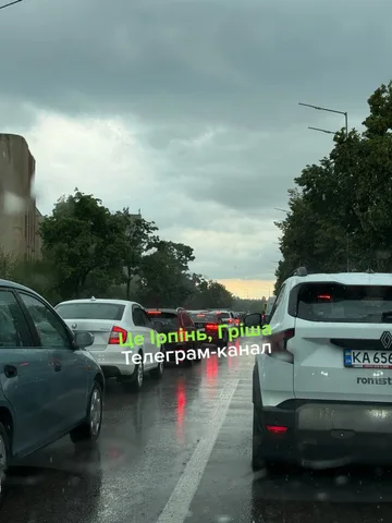 Затор на вулиці під час дощу, припаркована поліцейська машина