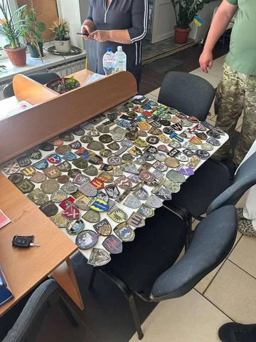 Колекція військових шевронів на столі в приміщенні