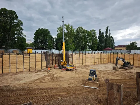 Будівельний майданчик з жовтим краном і технікою