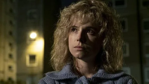 Портрет жінки з довгим хвилястим волоссям у светрі