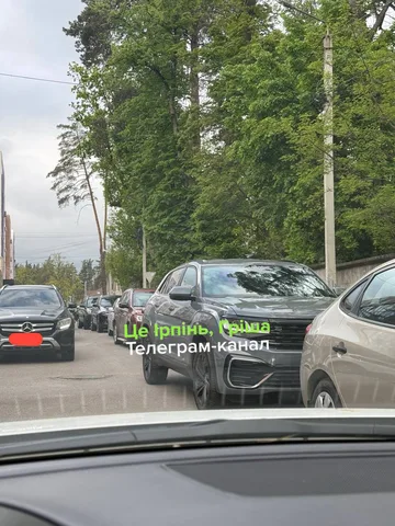 Припаркована в ряд автомобілі на вулиці біля парку