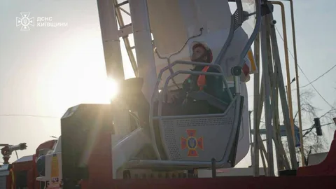 Рятувальник у кошику автовишки під час гасіння пожежі