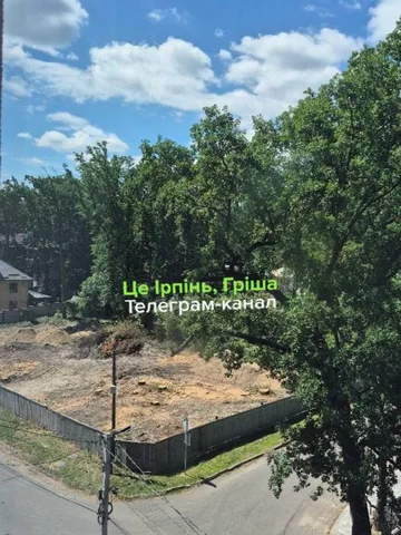 Ділянка землі з вирубаними деревами та будівельним огорожею